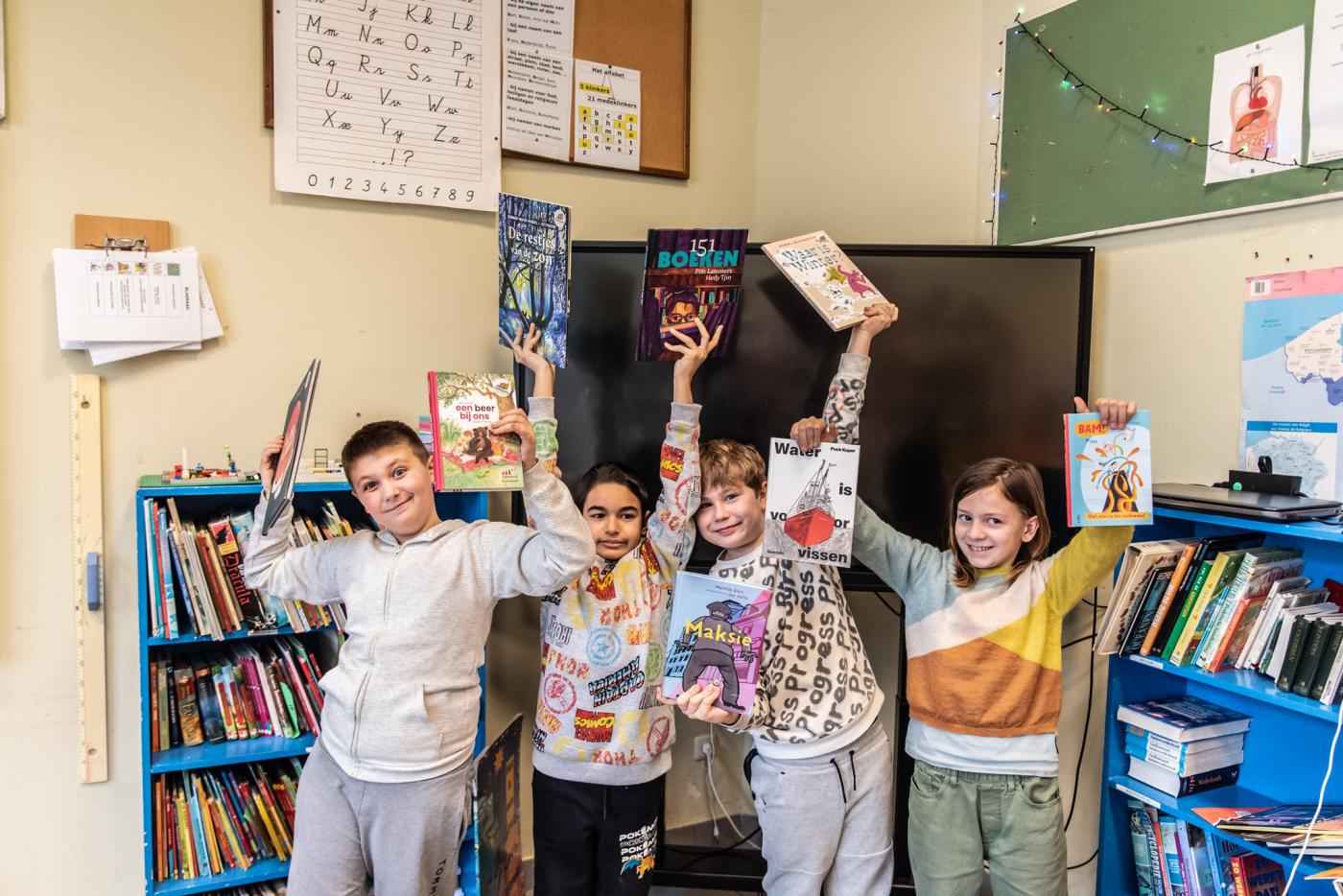 juryleden van de Leesjury houden blij een aantal boeken in de lucht