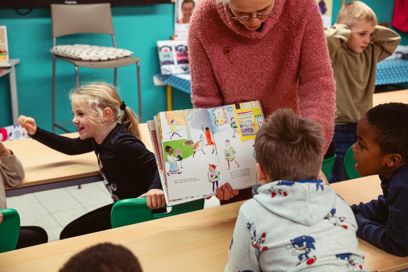 voorlezer gaat de klas rond om prent van dichtbij te laten zien 